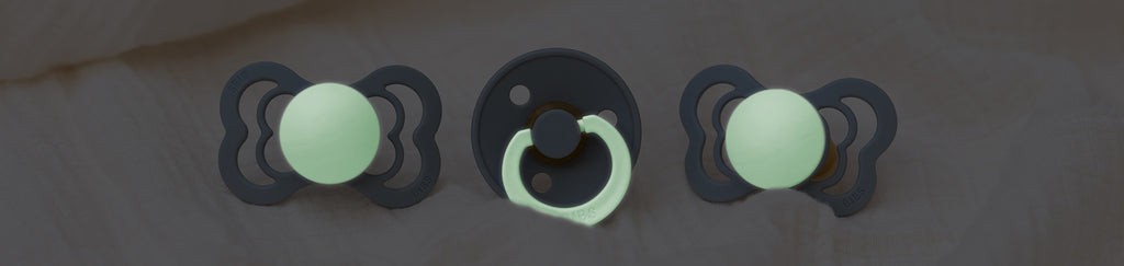 Three green pacifiers with black dots on them.